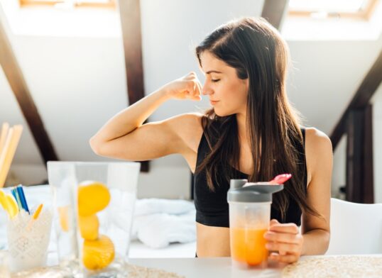 stock-photo-woman-at-home-drinking-orange-flavored-amino-acid-vitamin-powder-keto-supplement-after-exercise-1690737631-transformed